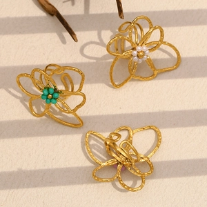 Detail of 18K gold plated flower ring with colorful beads on minimalist sand background