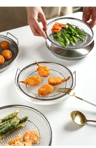 Macro shot of stainless steel cooling rack holding fried shrimp and crispy appetizers