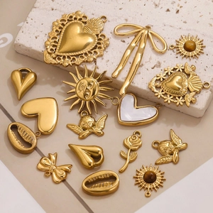 Macro view of gold-plated stainless steel angel and sun charms for DIY jewelry design