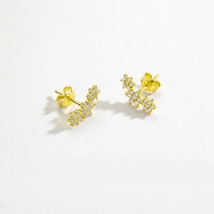 Detail of gold floral stud earrings featuring sparkling cubic zirconia stones