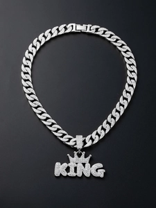 Close-up of iced out silver KING crown pendant with shimmering crystal cuban chain
