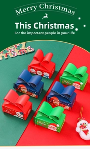 Close-up of Christmas paper gift boxes featuring festive cartoon illustrations and bows