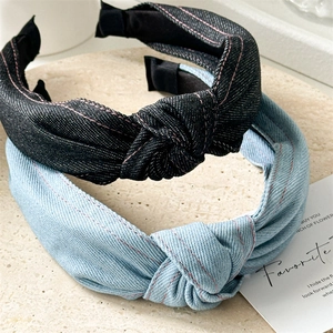 Détail de serre-têtes en denim noué avec surpiqûres roses et texture sergée