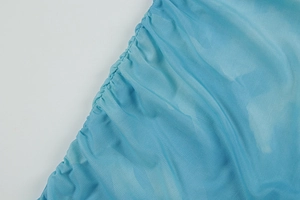 Détail en gros plan du tissu en maille bleue avec bords volantés et texture légère