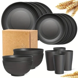 Macro view of a 16-piece matte black plastic dinnerware set with plates, bowls, and mugs