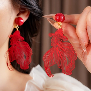 Gros plan détaillé de boucles d'oreilles clips poisson rouge ajouré style rétro