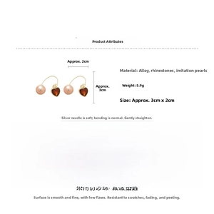 Détail macro des boucles d'oreilles cœur en strass avec perles et dimensions