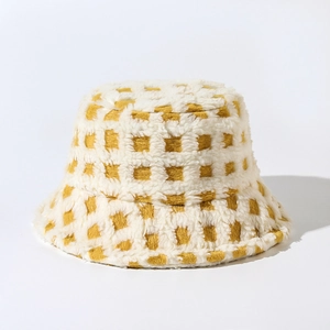 Close-up of yellow and beige checkered plush bucket hat showing thick faux fur texture