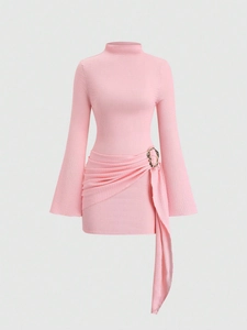 Détails du tissu rose, manches cloche, boucle dorée et plis asymétriques sur la robe