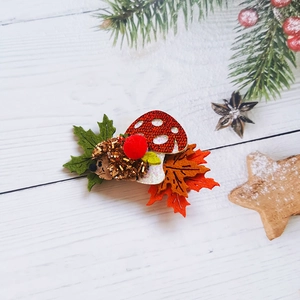 Detail of handmade mushroom and hedgehog hair clip with festive sequins and felt
