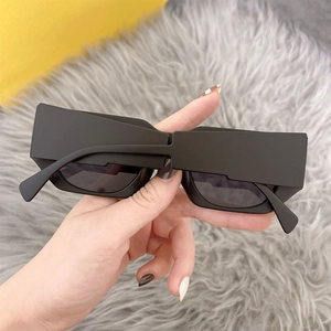 Detail of square matte black sunglasses with bold geometric frame and dark grey lenses