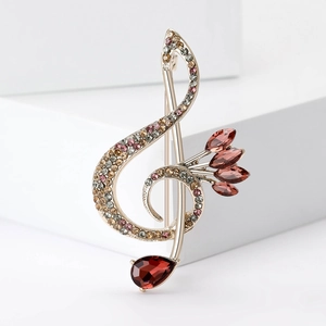 Elegant treble clef musical note brooch with colorful rhinestones on white base