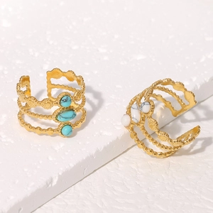 Detail of golden triple-row wave rings with blue turquoise and white natural stones