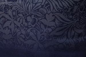 Macro shot of navy blue polo shirt fabric with subtle floral prints and fine texture
