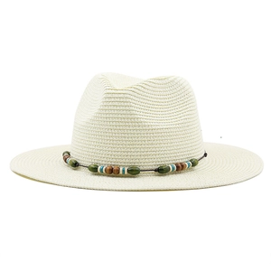 Detail of light beige straw fedora hat with bohemian style colorful beaded band decoration