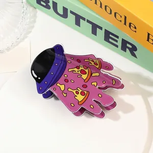 Close-up of a whimsical purple UFO and pizza beam acrylic hair claw on a white tray