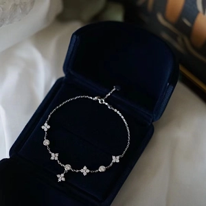 Close-up of 925 sterling silver clover bracelet with zircon in a blue velvet jewelry box