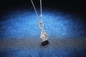 Macro shot of 925 silver infinity pendant with sparkling solitaire moissanite stone