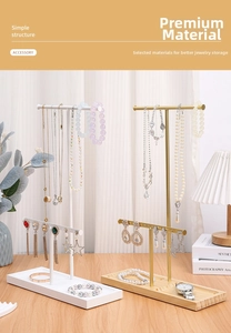 Detail view of a metal jewelry organizer with a wooden base for earrings and necklaces