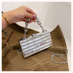 Detailed view of silver metallic box bag with chunky chain handle and stripe texture