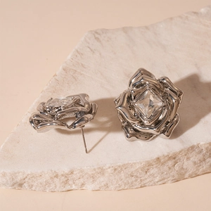 Détail de boucles d'oreilles rose argentée avec zircon carré sur une pierre naturelle