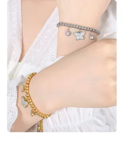 Detailed view of beaded butterfly charm bracelet with sparkling zircons on model's wrist