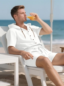 Close-up of white linen hooded short sleeve shirt and shorts set on a beach chair