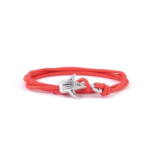 Detail of red braided rope bracelet with silver whale shark charm and spotted texture