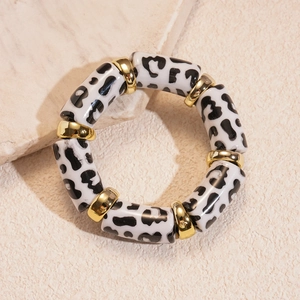 Detailed macro view of acrylic leopard print round beads and gold metal spacers