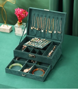 Macro shot of green velvet jewelry box interior with necklace hooks and multi-layer storage