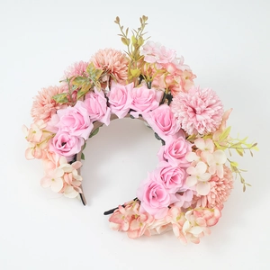 Detail of pink roses and peach hydrangeas on a dense floral headband with green leaves