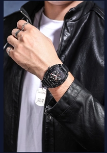 Close-up of men's black skeleton mechanical watch with leather strap and punk accessories
