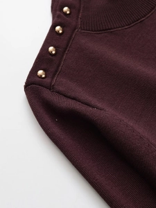 Detail of burgundy knit sweater showing ribbed neckline and four gold dome buttons