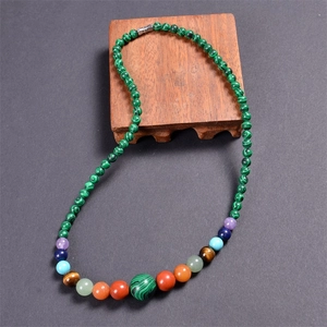 Detail shot of colorful 6mm natural stone beads and chakra gems on a dark textured surface