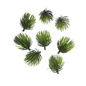 Flat lay of eight green artificial pine needles for DIY crafts and holiday decor