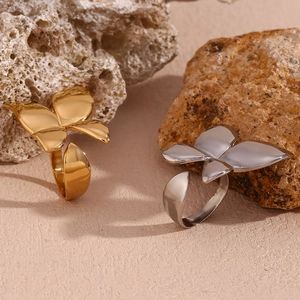 Detail of polished butterfly open rings in gold and silver finish on natural stones