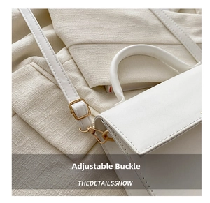 Detailed shot of white leather handbag with adjustable strap and gold metal buckle