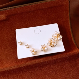 Détail de boucles d'oreilles en perles et cristaux plaqués or 18k dans une boîte