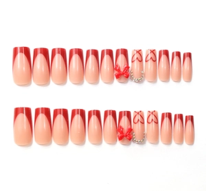 Détails de faux ongles carrés longs avec nœuds rouges, cœurs et strass brillants
