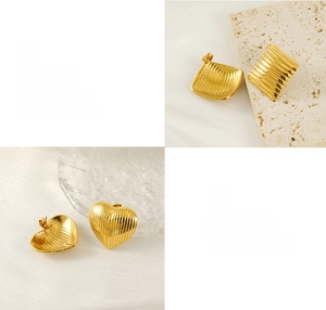 Detail showing polished gold geometric earrings with brushed texture on stone display