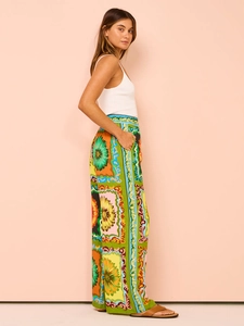 Detail of high waist printed wide leg pants featuring floral geometric patterns and pockets