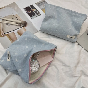 Gros plan sur la trousse à maquillage en jean avec motifs étoiles et étiquette tissée