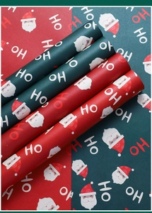 Macro detail of waterproof Christmas wrapping paper with red and green Santa motifs