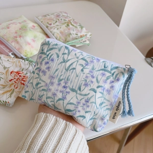 Detailed close-up of floral cotton coin purses with smooth zippers and woven pull tabs