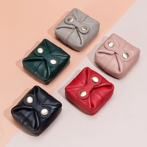 Five assorted colors of mini leather coin purses with metallic snaps on colorful background