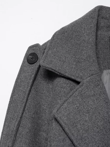 Detail shot of the dark gray wool coat collar and shoulder with a classic black button
