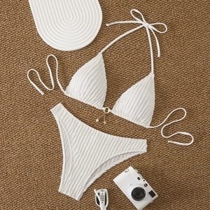 Detail of white bikini set featuring ribbed fabric, golden chain and pearl charms