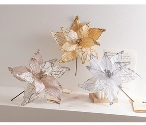 Detailed view of pink and gold artificial poinsettia flowers with glittering sequins
