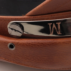 Macro detail of brown lychee pattern leather hat with silver M metal plate