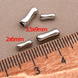 Dettaglio macro di perline a tubo d'argento 3,5x9mm e 2x6mm con righello graduato